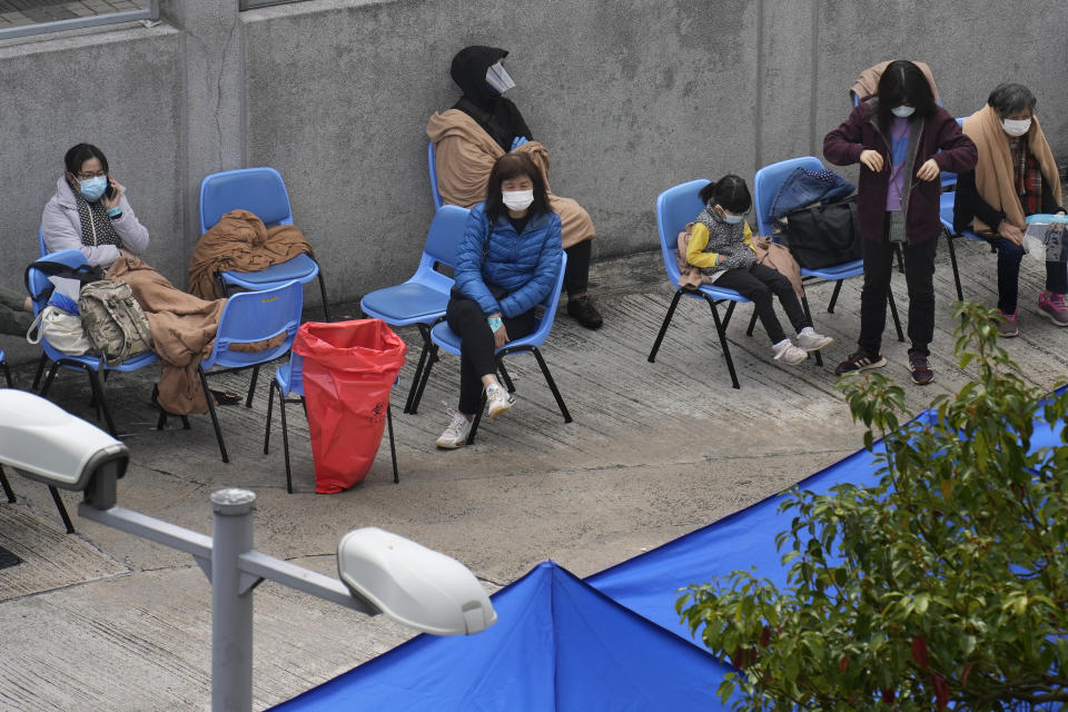 People including current hospital patients showing COVID-19 symptoms wait at a temporary holding area outside Caritas Medical Centre in Hong Kong Wednesday, Feb. 16, 2022. (AP Photo Vincent Yu)