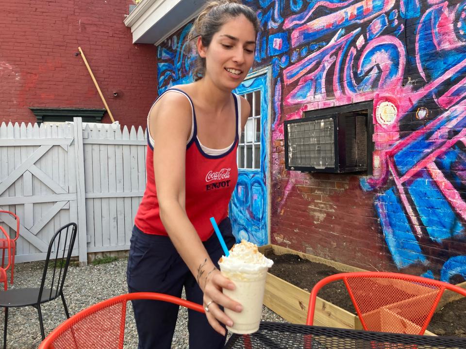 Mairav Simon brings a maple milkshake at Maudite Poutine in Burlington on May 20, 2022.