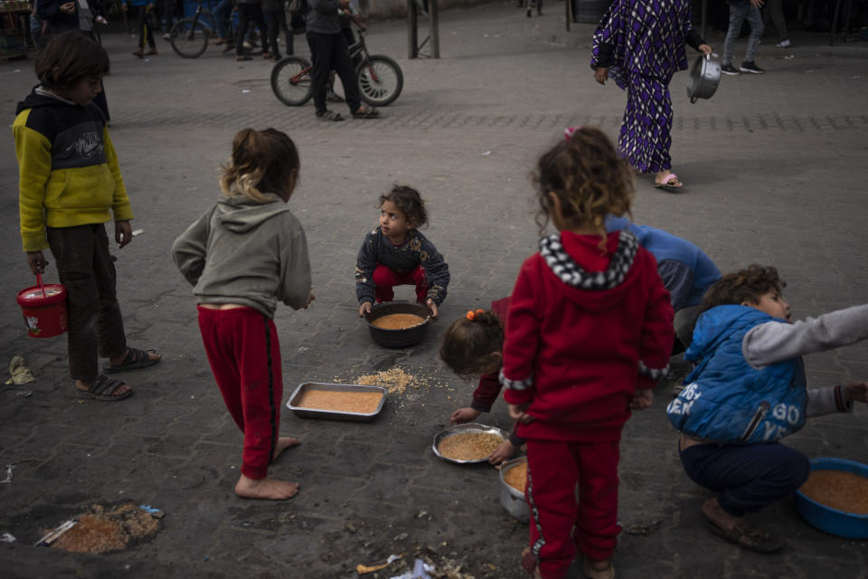 Palestinian kids receive free food in Rafah, Gaza Strip, Friday, Feb. 23, 2024. An estimated 1.5 million Palestinians displaced by the war took refuge in Rafahor, which is likely Israel's next focus in its war against Hamas. (AP Photo/Fatima Shbair)