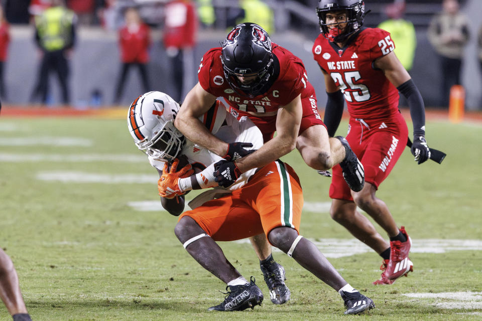 Miami's Donald Chaney, Jr., left, is tackled by North Carolina State's Payton Wilson (11) during the second half of an NCAA college football game in Raleigh, N.C., Saturday, Nov. 4, 2023. (AP Photo/Ben McKeown)