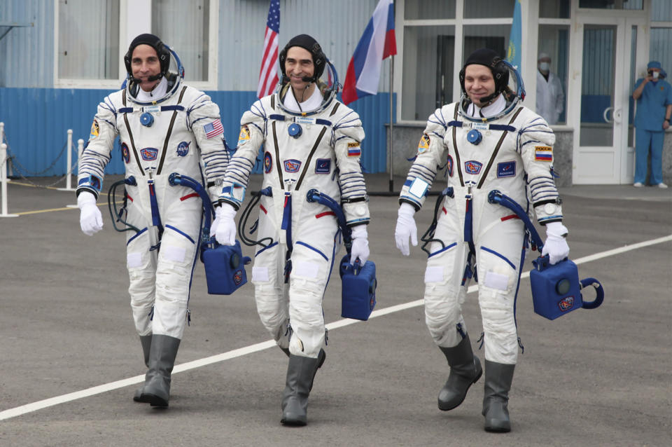 In this handout photo released by Roscosmos Space Agency Press Service U.S. astronaut Chris Cassidy, left, Russian cosmonauts Anatoly Ivanishin, centre, and Ivan Vagner, members of the main crew of the expedition to the International Space Station (ISS), walk prior the launch of Soyuz MS-16 space ship at the Russian leased Baikonur cosmodrome, Kazakhstan, Thursday, April 9, 2020. (Roscosmos Space Agency Press Service via AP)