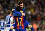 Barcelona's Paco Alcacer (bottom) celebrates with teammate Lionel Messi during their match against Real Sociedad at the Camp Nou stadium in Barcelona on April 15, 2017