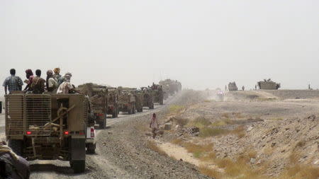 Fighters loyal to Yemen's President Abd-Rabbu Mansour Hadi ride on armoured personnel carrier vehicles on a road leading to the al-Anad military and air base in the country's southern province of Lahej August 3, 2015.REUTERS/Stringer