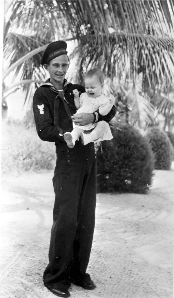 Coast Guard lighthouse keeper William Robert "Bob" England Jr. holding his daughter Margaret in 1946.