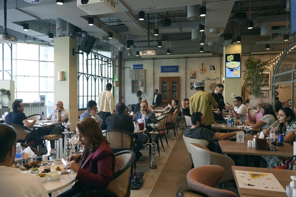 Gente pidiendo comida en el restaurante Hadoota Masreya en Dubái, Emiratos Árabes Unidos, el 5 de septiembre de 2022. El restaurante tiene cocineros y camareros egipcios, aunque sirve a una clientela de todo el mundo. (AP Foto/Malak Harb)