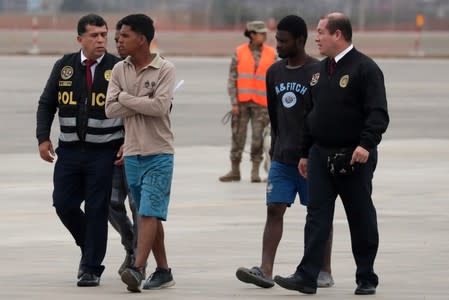 Peruvian immigration police escort Venezuelan migrants prior to their deportation, after being accused of concealing that they had criminal records, according to Peru's Interior Ministry, in Lima