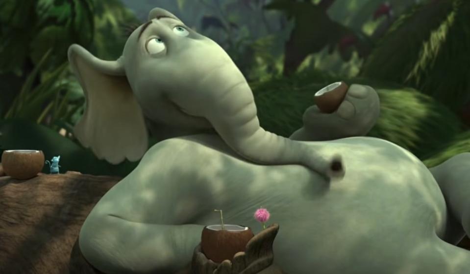 Horton the Elephant lounging on the ground while holding a coconut drink