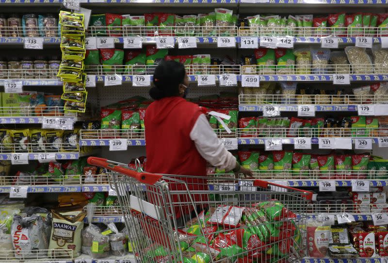 A worker arranges staple goods inside a Reliance supermarket in Mumbai