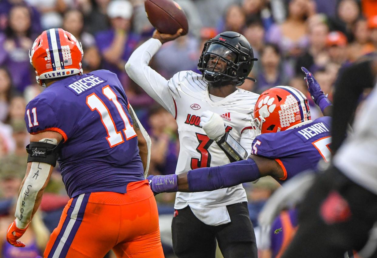 Louisville quarterback Malik Cunningham (3) passes as he is pressured by Clemson defensive lineman Bryan Bresee (11) and defensive end K.J. Henry (5) during the second quarter at Memorial Stadium in Clemson, South Carolina Saturday, Nov. 12, 2022.