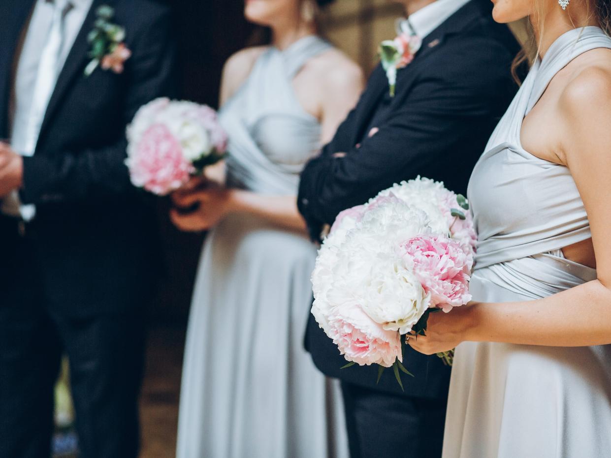 members of the bridal party standing in a line dressed up for a wedding