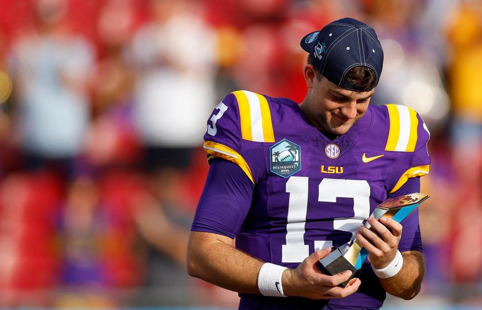 TAMPA, FLORIDA - JANUARY 01: Garrett Nussmeier #13 of the LSU Tigers poses with the MVP trophy after winning the ReliaQuest Bowl against the Wisconsin Badgers at Raymond James Stadium on January 01, 2024 in Tampa, Florida. (Photo by Mike Ehrmann/Getty Images)