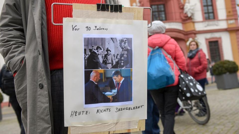 Un manifestante en Alemania porta un cartel comparando lo sucedido en Turingia con el ascenso de Adolf Hitler.