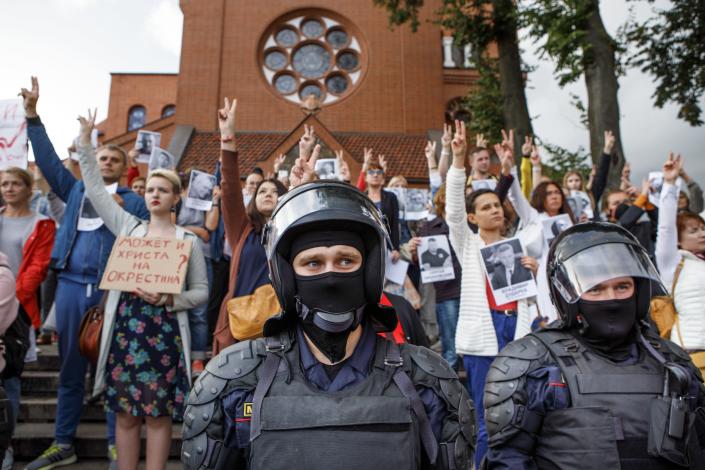 Riot police block protesters in front of a Catholic church in Minsk, Belarus, Thursday, Aug. 27, 2020. Police in Belarus have dispersed protesters who gathered on the capital's central square, detaining dozens. (AP Photo/Dasha Sapranetskaya )