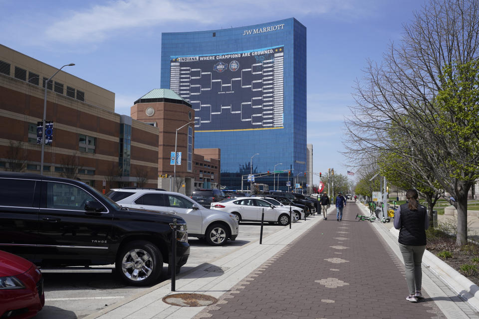 Mikela Earley walks to a hotel for an order for a customer who is inside of the bubble while in town for the NCAA men's college basketball tournament, Tuesday, March 30, 2021, in Indianapolis. The NCAA and local organizing groups set up expanded ambassador and item-delivery services relying on volunteer help to take care of needs for players, officials and others working inside. (AP Photo/Darron Cummings)