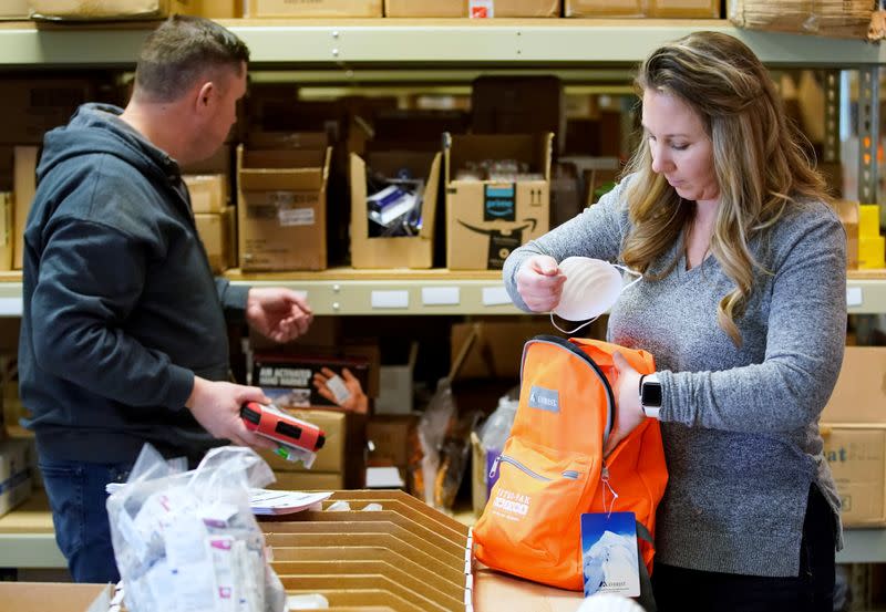 Kristen Curley (R), owner of Nitro-Pac, and an employee, puts items into a backpack as part of personal protection and survival equipment kits ordered by customers preparing against novel coronavirus, at Nitro-Pak in Midway