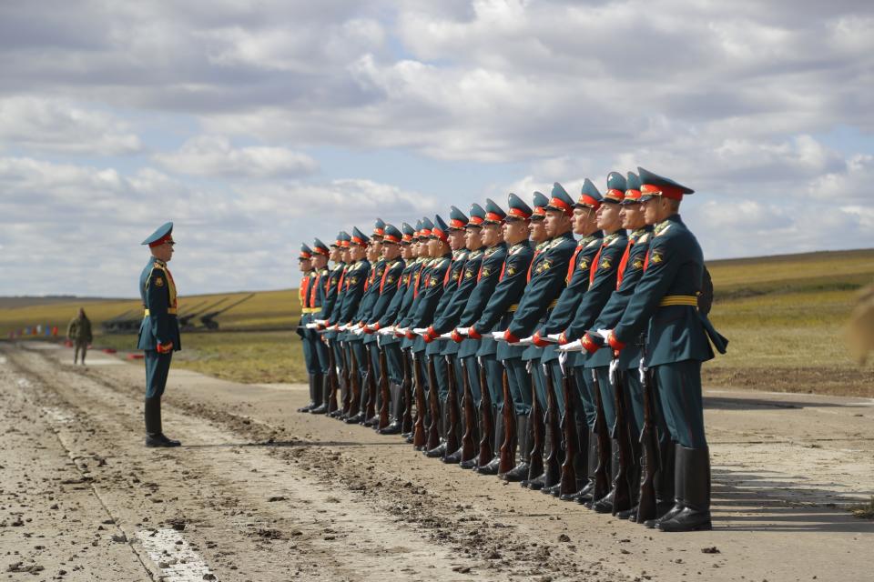 FILE - In this Thursday, Sept. 13, 2018 file photo a Russian honor guard prepares to take a part in a parade prior to a military exercises on training ground "Tsugol", about 250 kilometers (156 miles ) south-east of the city of Chita during Vostok 2018 in Eastern Siberia, Russia. The weeklong Vostok (East) 2018 maneuvers launched Tuesday span vast expanses of Siberia and the Far East, the Arctic and the Pacific Oceans. They involve nearly 300,000 Russian troops along with 1,000 Russian aircraft and 36,000 tanks and other combat vehicles. (AP Photo/Sergei Grits, File)