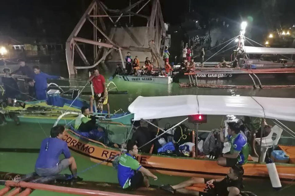In this photo provided by the Philippine Coast Guard, rescuers conduct operations at the collapsed old Clarin Bridge at the coastal town of Loay in Bohol province, central Philippines, on Wednesday April 27, 2022. The old, earthquake-damaged bridge collapsed under heavy traffic in a central Philippine town, sending about a dozen vehicles plummeting into the river below and killing at least four people, officials said Thursday. (Philippine Coast Guard via AP)