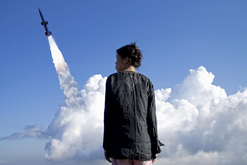 Portrait of a woman against rocket launch