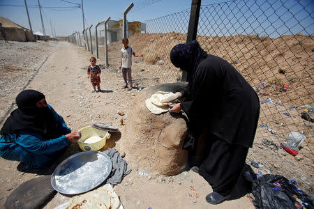 Displaced Iraqi women from Talafar make bread in Salamya camp, east of Mosul, Iraq August 6, 2017. REUTERS/Khalid Al-Mousily