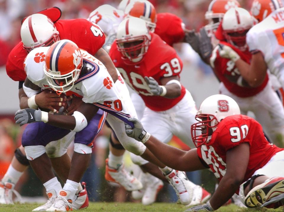 Clemson Bernard Rambert (20) is brought down by N.C. State's Chance Moyer (49), left, and Terrance martin (90) during the 1st half Saturday, October 13, 2001 at N.C. State's Carter Finley Stadium. 