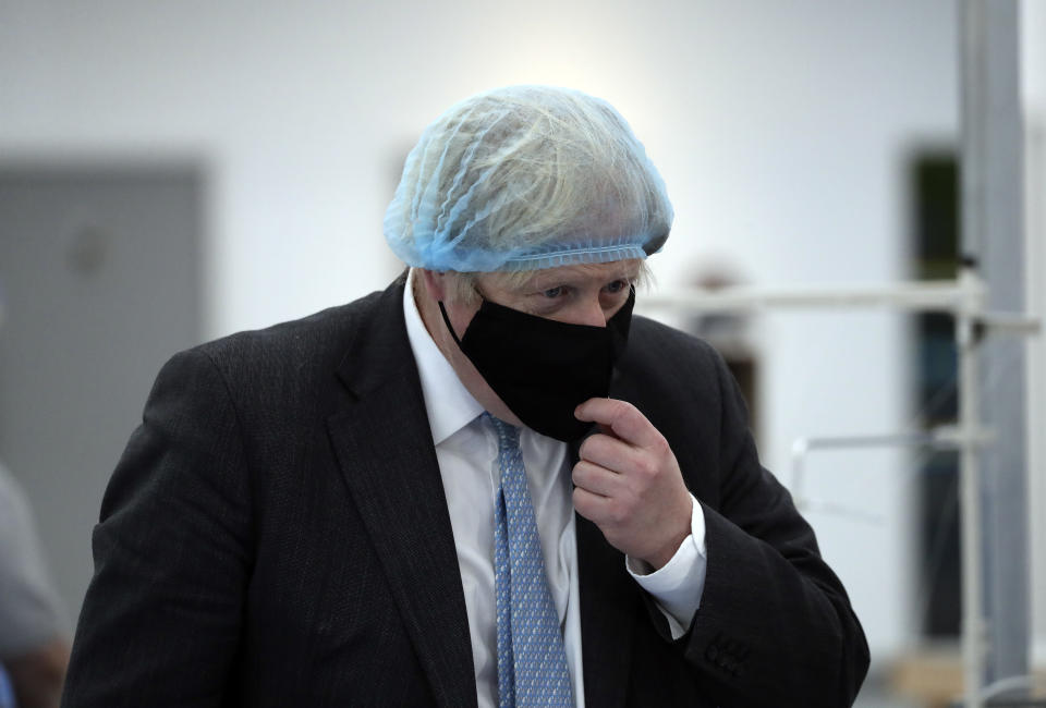 Britain's Prime Minister Boris Johnson, wearing a face mask to prevent the spread of the coronavirus, visits a PPE manufacturing facility during a visit to the north east of England, in Seaton Delaval, England, Saturday, Feb. 13, 2021. (AP Photo/Scott Heppell, Pool)