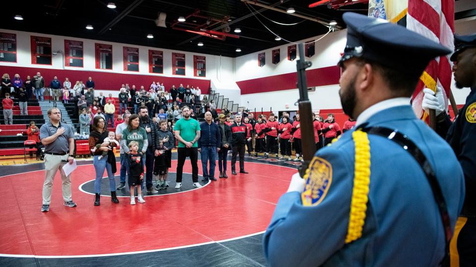 Family members of Trooper Sean Cullen and Sgt. Bryan L. Freeman Jr. stand on the wrestling mat and take part in a moment of silence in memory of Trooper Cullen and Sgt. Freeman prior to the 6th Annual Wrestling for Heroes Match between Cinnaminson and Rancocas Valley held at Cinnaminson High School on Wednesday, January 25, 2023.