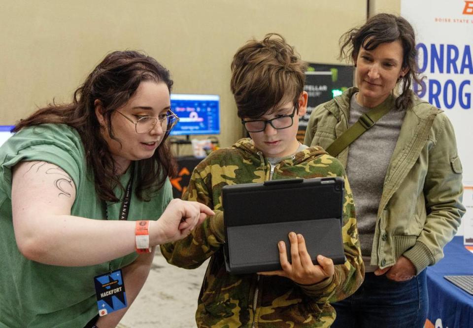 Onramp Program volunteer Emma DiNucci, left, helps Hackfort attendees Bertie Andreae, 10, of Boise, and his mother, Val Kiersig, create an augmented reality experience using a tablet at Hackfort on Thursday. Onramp Program is sponsored by Boise State University, College of Western Idaho, Idaho Digital Learning Alliance and Apple Community Education Initiative.