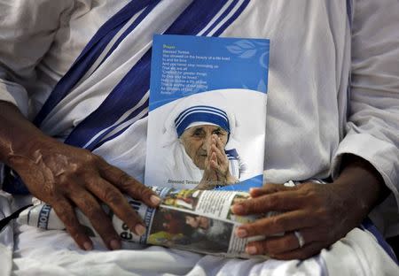 A Catholic nun from the Missionaries of Charity, the global order of nuns founded by Mother Teresa, holds a pamphlet as she attends a prayer meeting on Mother Teresa's 13th death anniversary in Kolkata, India, in this September 5, 2010 file photo. REUTERS/Rupak De Chowdhuri/Files