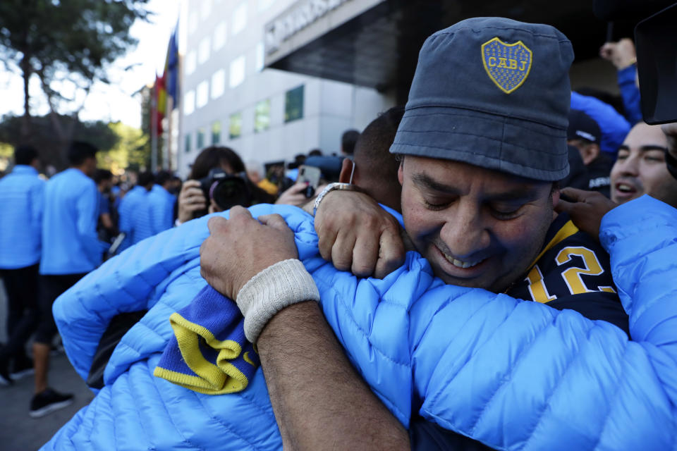 Boca Juniors' Sebastian Villa, center, is hugged by a supporter as the team arrives at their hotel in Madrid Saturday, Dec. 8, 2018. The Copa Libertadores Final between River Plate and Boca Juniors will be played on Dec. 9 in Madrid, Spain, at Real Madrid's stadium. (AP Photo/Manu Fernandez)