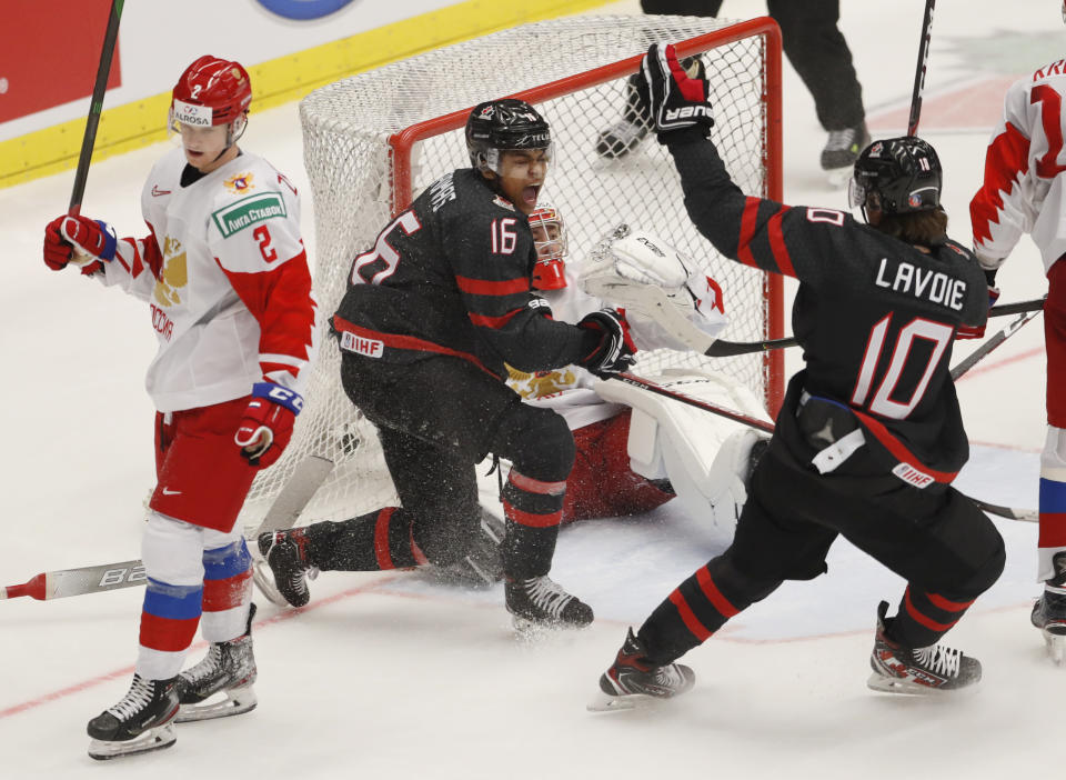 Canada's Akil Thomas, 2nd left, celebrates with Canada's Raphael Lavoie, right, after scoring his sides winning goal past Russia's goaltender Amir Miftakhov, 2nd right, and Russia's Danil Zhuravlyov, left, during the U20 Ice Hockey Worlds gold medal match between Canada and Russia in Ostrava, Czech Republic, Sunday, Jan. 5, 2020. (AP Photo/Petr David Josek)