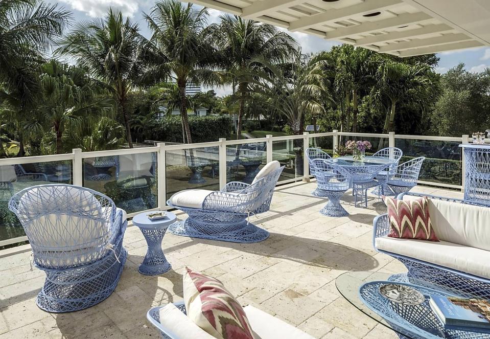 A large deck with rattan sofas, chairs, and tables