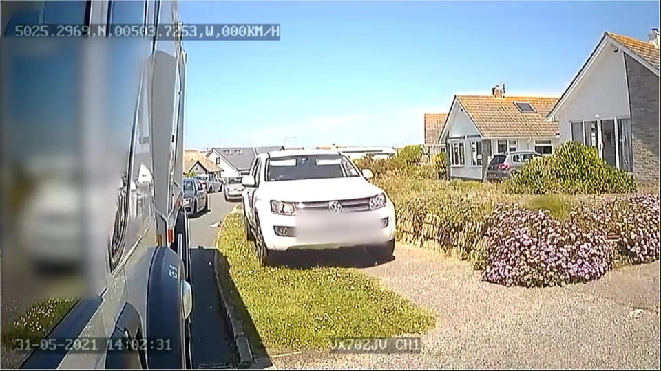 A car uses the pavement to get past a bin lorry. (SWNS)