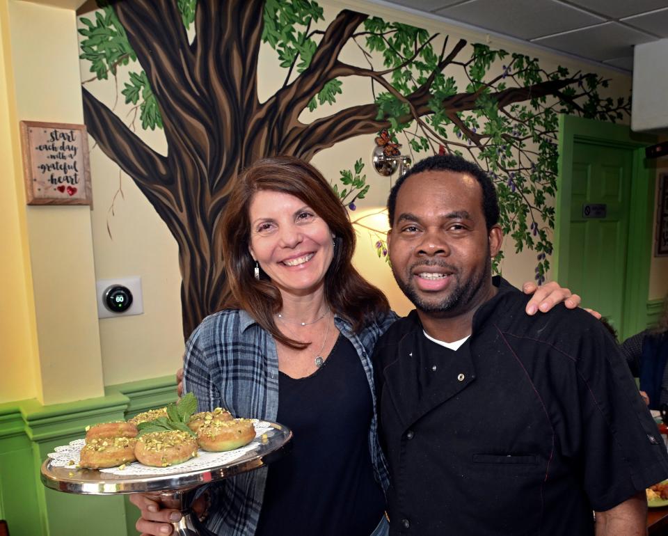 Owner Maria Ferguson and chef Oneil Reid at the Fig Tree Cafe in Marstons Mills. She is holding baked pistachio doughnuts.