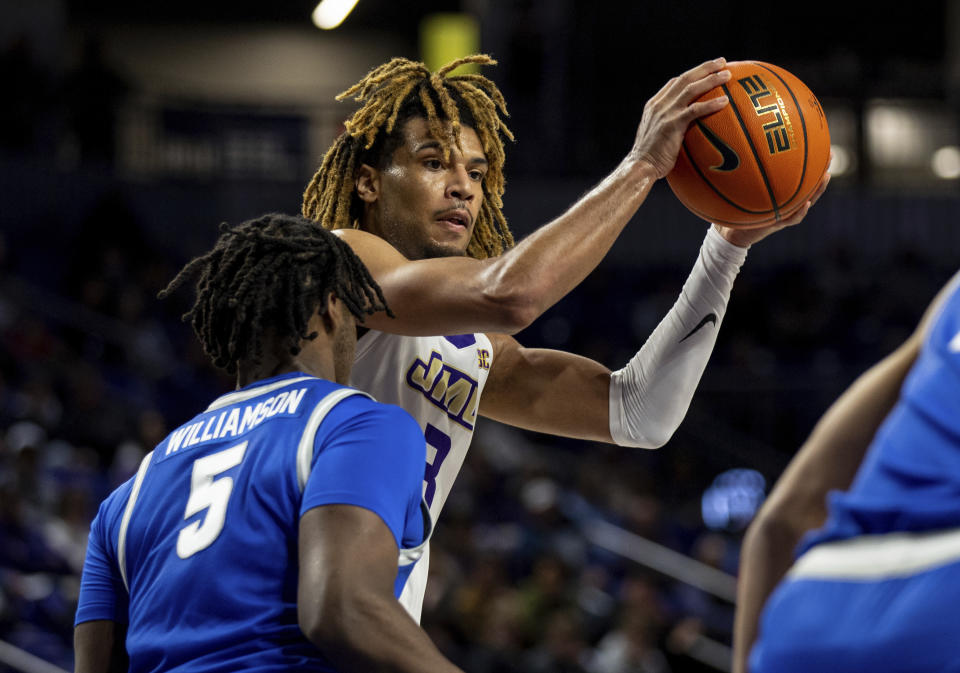 James Madison forward T.J. Bickerstaff (3) looks for an open teammate around Buffalo forward Zaakir Williamson (5) during the first half of an NCAA college basketball game in Harrisonburg, Va., Wednesday, Nov. 29, 2023. (Daniel Lin/Daily News-Record Via AP)