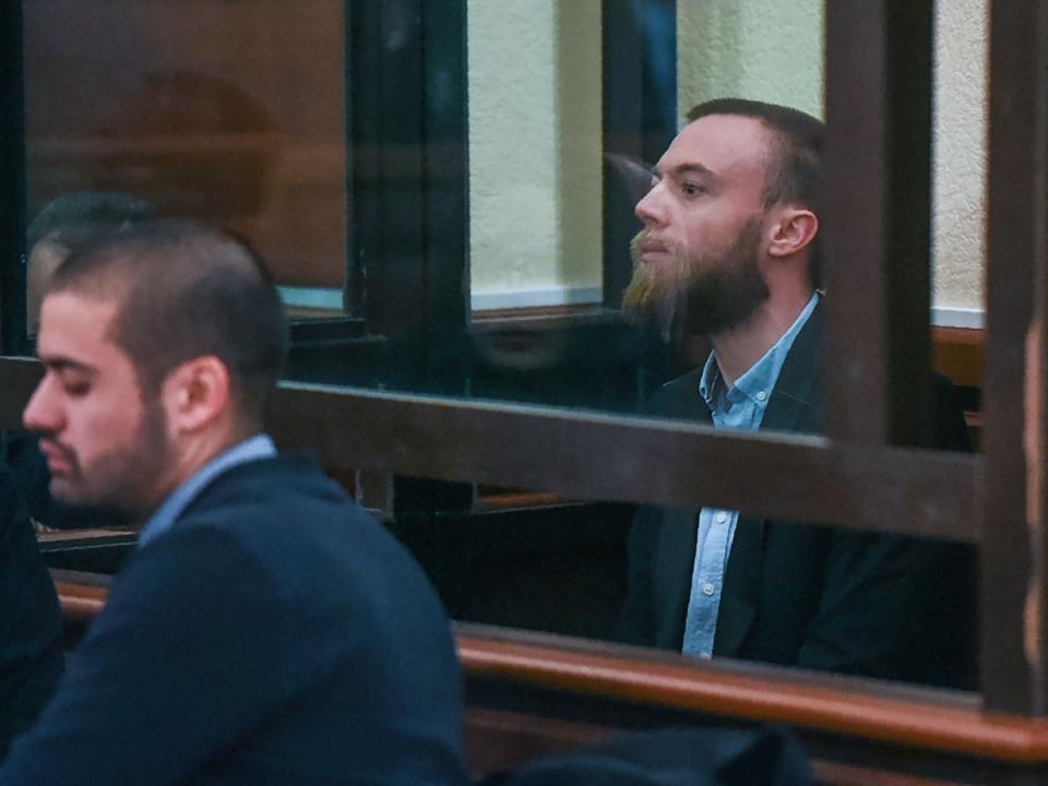 Jack Shepherd sits inside a defendants’ cage during an extradition hearing at a court in Tbilisi, Georgia in January 2019 (AFP)