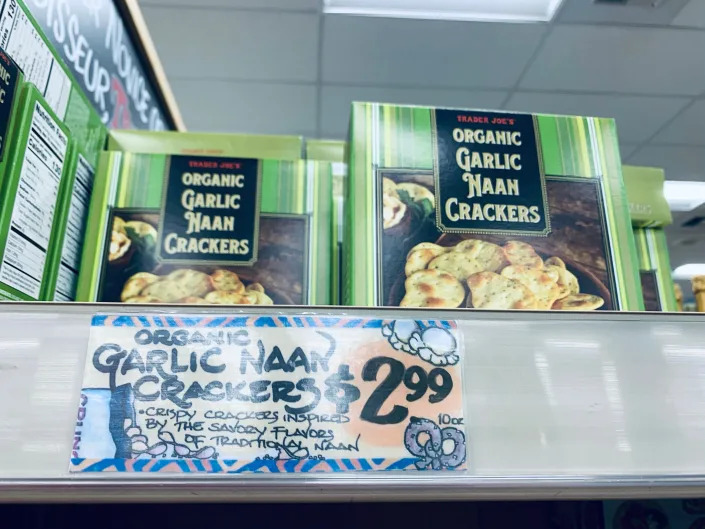 green Boxes of trader joe's garlic naan crackers on shelf at store