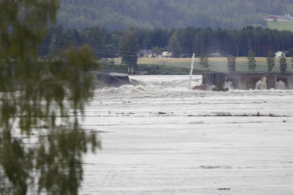 Water overflows the dam at Braskereidfoss, Norway, Wednesday, Aug. 9, 2023. Authorities in Norway say a dam has partially burst following days of heavy rain that triggered landslides and flooding in the mountainous southern parts of the country. Communities downstream already had been evacuated. (Cornelius Poppe/NTB Scanpix via AP)