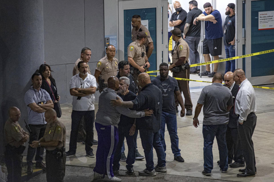 Police officers and other officials stand outside the Ryder Trauma Center after a Miami-Dade police officer was shot in an exchange of gunfire during a car chase with an armed robbery suspect, Monday, Aug. 15, 2022, in Miami. (Sydney Walsh/Miami Herald via AP)