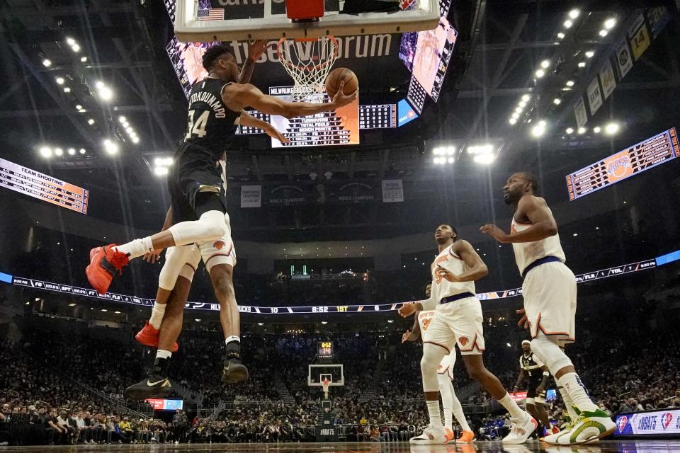 Milwaukee Bucks' Giannis Antetokounmpo is foukled by New York Knicks' Mitchell Robinson as he shoots during the first half of an NBA basketball game Friday, Jan. 28, 2022, in Milwaukee. (AP Photo/Morry Gash)