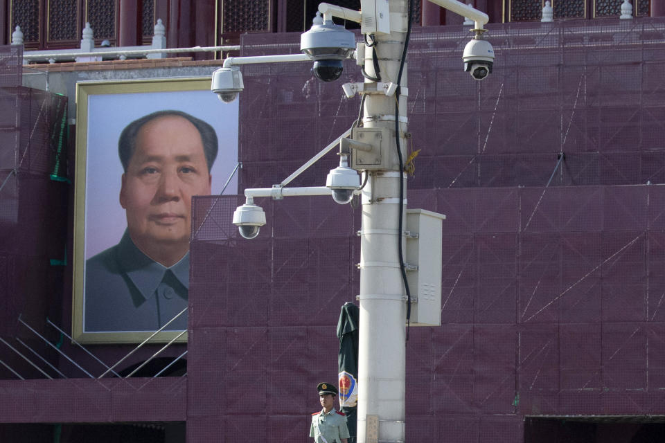 In this May 31, 2019, photo, a Chinese paramilitary policeman stands guard near surveillance cameras in front of Mao Zedong's portrait on Tiananmen Gate in Beijing. Critics say the 1989 Tiananmen crackdown, which left hundreds, possibly thousands, dead, set the ruling Communist Party on its present course of ruthless suppression, summary incarceration and the frequent use of violence against opponents in the name of "stability maintenance." (AP Photo/Ng Han Guan)