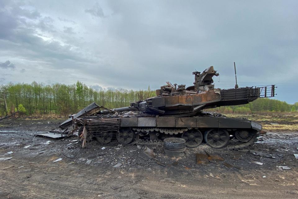 A destroyed tank in a field.