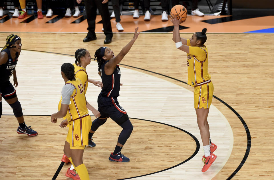 Southern California guard JuJu Watkins, right, shoots the ball over UConn guard Qadence Samuels, second from right, during the first half of an Elite Eight college basketball game in the women's NCAA Tournament, Monday, April 1, 2024, in Portland, Ore. (AP Photo/Steve Dykes)