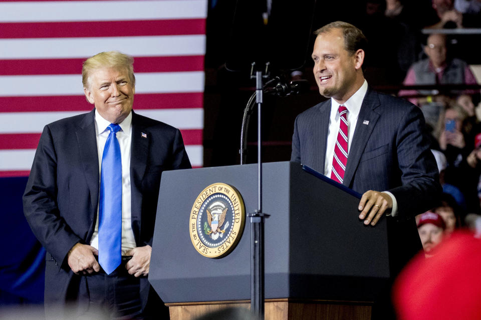 In this Oct. 13, 2018 photo, President Donald Trump, left, listens as Rep. Andy Barr, R-Ky., right, speaks at a rally at Alumni Coliseum in Richmond, Ky. The Lexington-area battle pits third-term Republican Rep. Andy Barr against Democrat Amy McGrath, a retired Marine fighter pilot. Trump won the 6th District by more than 15 percentage points in 2016. But with the help of carefully-shaped campaign ads that went viral, McGrath holds the edge on campaign fundraising. (AP Photo/Andrew Harnik)