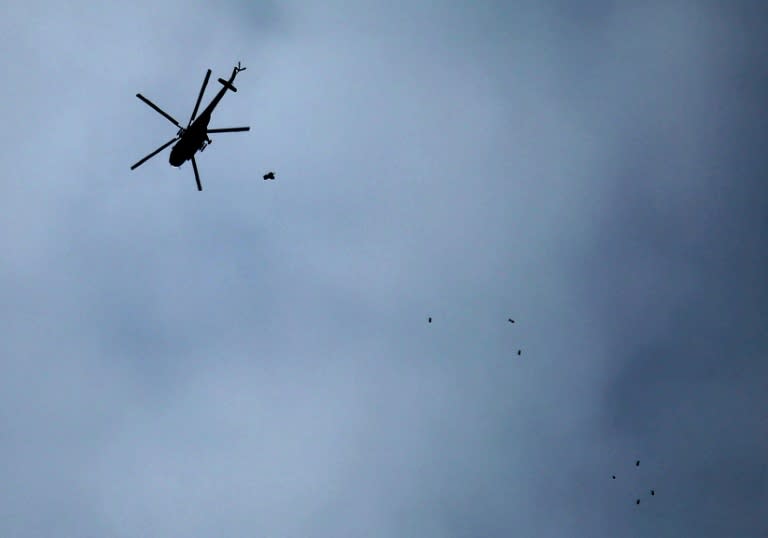 A Russian-made Syrian regime helicopter drops bombs on the rebel-held town of Arbin in the besieged Eastern Ghouta region on February 20, 2018