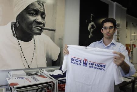 Raul Moas holds a t-shirt of his organization "Roots of Hope" in Miami Beach, Florida, December 19, 2014. REUTERS/Javier Galeano