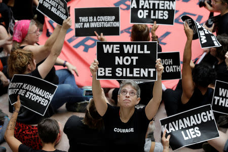 Activists rally inside the Senate Hart Office Building during a protest in opposition to U.S. Supreme Court nominee Brett Kavanaugh and in support of Christine Blasey Ford, the university professor who has accused Kavanaugh of sexual assault in 1982, on Capitol Hill in Washington, U.S., October 4, 2018. REUTERS/Yuri Gripas