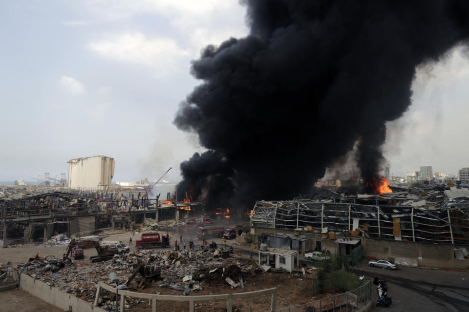 FILE - In this Sept. 10. 2020 file photo, firefighters work to extinguish a fire at warehouses at the seaport in Beirut, Lebanon. An economic meltdown, a revolution, financial collapse, a virus outbreak and a cataclysmic explosion that virtually wiped out the country's main port. The past year has been nothing short of an earthquake for tiny Lebanon, with an economic meltdown, mass protests, financial collapse, a virus outbreak and a cataclysmic explosion that virtually wiped out the country’s main port. Yet Lebanese fear even darker days are ahead. (AP Photo/Hassan Ammar, File)