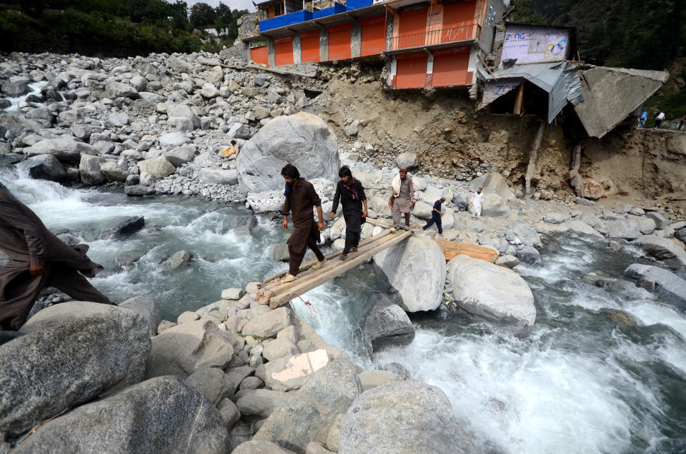 A view of flood disaster area as people carry food on their backs due to flood-destroyed bridges and roads in Pakistan in Khyber Pakhtunkhwa province of Swat, Pakistan on September 05, 2022. (Hussain Ali/Anadolu Agency via Getty Images)