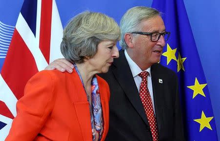 British Prime Minister Theresa May (L) is welcomed by European Commission President Jean-Claude Juncker at the EC headquarters in Brussels, Belgium October 21, 2016. REUTERS/Yves Herman/Files