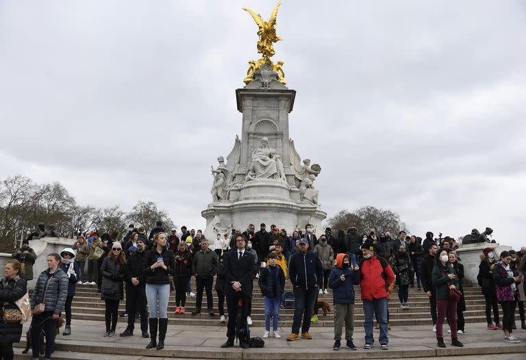 La gente se reúne alrededor del Queen Victoria Memorial cerca del Palacio de Buckingham en Londres, un día después de la muerte del Príncipe Felipe de Gran Bretaña,